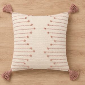 Handwoven ivory cotton cushion cover with blush pink stripes, textured tufted details, and decorative tassels, displayed on a wooden background.